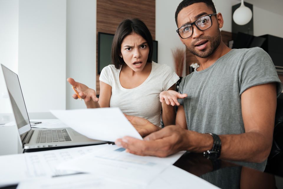 Understanding Creditor Harassment - confused-couple-discussing-bills