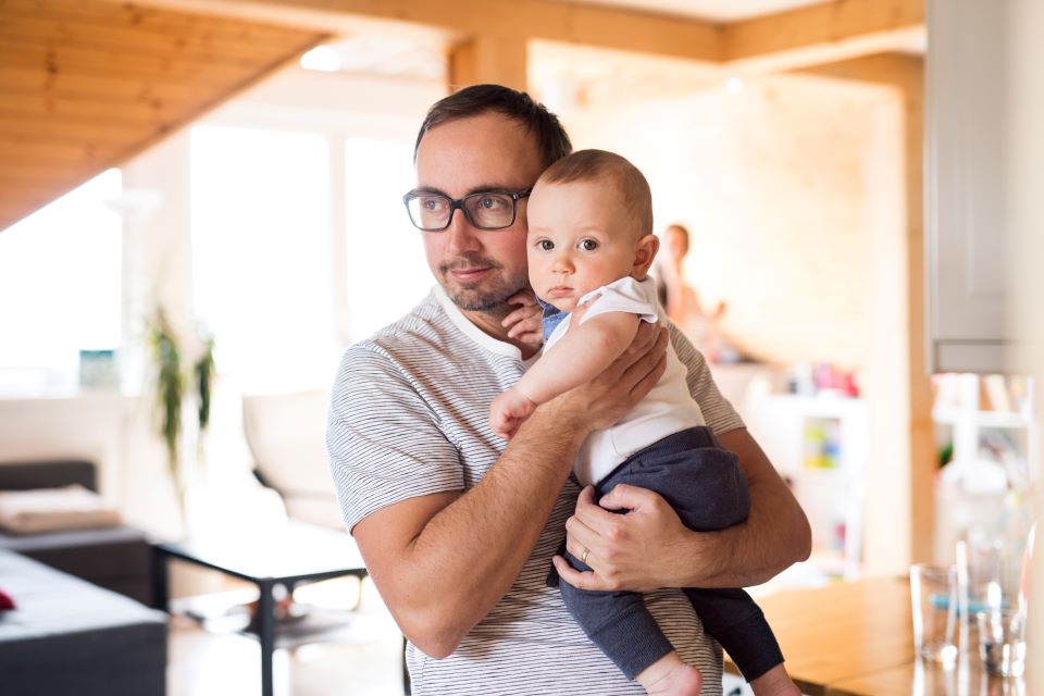 Understanding Creditor Harassment - loving-father-at-home-cradling-his-adorable-baby-son