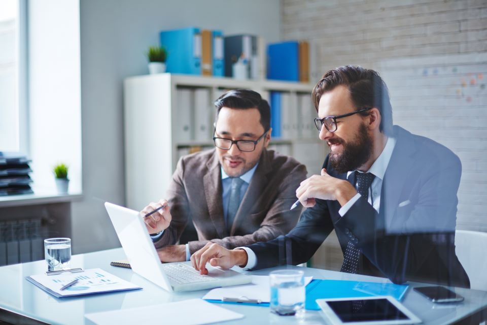 two-male-employees-discussing-business-project-at-meeting